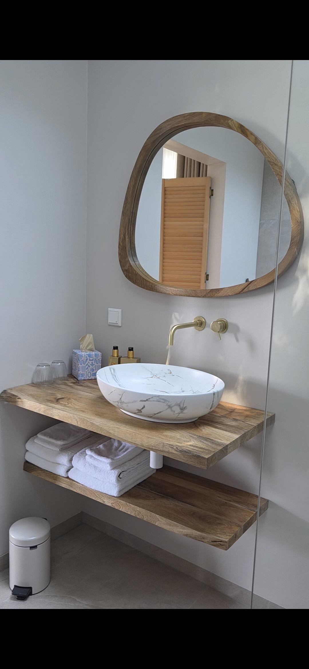 Luxe badkamer met marmeren waskom en goudkleurige kraan